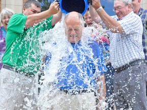 Perth-Wellington MPP Randy Pettapiece braces himself as West Perth Coun. Doug Eidt (left), and Mayor Walter McKenzie pour ice water over him during the Amyotrophic lateral sclerosis (ALS) ice bucket challenge last Wednesday, Aug. 27 on the steps of the municipal building in Mitchell. KRISTINE JEAN/MITCHELL ADVOCATE