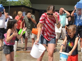 Denise Nicholson, middle, and her daughters, Mya, left, and Peyton react after pouring cold water over their heads at the Chatham ice bucket challenge in Tecumseh Park on Sunday. Another daughter, Lorenne, also took part in the fundraiser to support the ALS Society.