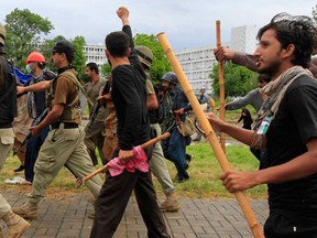 Supporters of Tahir ul-Qadri, Sufi cleric and leader of political party Pakistan Awami Tehreek (PAT), chant while walking with soldiers from the Pakistan Rangers during the Revolution March towards prime minister's house in Islamabad September 1, 2014. Pakistani protesters pushed closer to the prime minister's house in central Islamabad on Monday in their bid to force his removal and forced national television off the air after clashes turned violent over the weekend. (REUTERS/Faisal Mahmood)