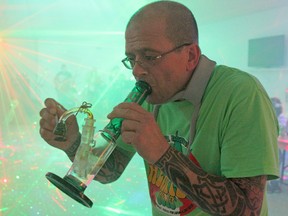 Robert Néron takes a hit from his bong at Hempfest 2014 on Saturday surrounded by friends, loud music and puffs of smoke. Despite being a proponent of legalization, Néron, who is medically licensed to receive and smoke marijuana, said he’s strongly opposed to politicians using the issue for their own political gain.