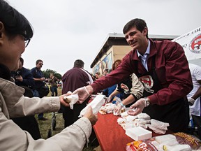 Edmonton mayor Don Iveson hands out burgers during the 25th anniversary Labour Day BBQ held by the Edmonton and District Labour Council at Giovanni Caboto Park in Edmonton, Alta., on Monday, Sept. 1, 2014. Codie McLachlan/Edmonton Sun/QMI Agency
