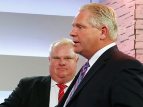 Mayor Rob Ford (L) talks to his brother Doug Ford during a break in the Toronto Mayoral election debate in Toronto, March 26, 2014.    REUTERS/Mark Blinch