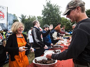 NDP MLA Rachel Notley hands out burgers during the 25th anniversary Labour Day BBQ held by the Edmonton and District Labour Council at Giovanni Caboto Park in Edmonton, Alta., on Monday, Sept. 1, 2014. Codie McLachlan/Edmonton Sun/QMI Agency