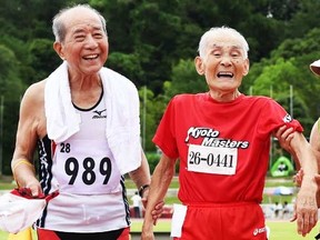 Japanese sprinter Hidekichi Miyazaki (C), 104, is helped by his daughter Kiyono (R) and 89-year-old athlete Hiroshi Miyamoto (L) after crossing the finish line of men's 100m dash at a Japan Masters Athletics competition in Kyoto on August 3, 2014. (AFP PHOTO/Toru YAMANAKA)