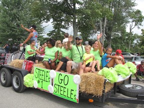 Members of the Steele family baseball team wave to the crowd during the Buxton Homecoming parade in 2014. The team was part of the Family Feud baseball tournament, which is one of the more popular attractions of the homecoming weekend.