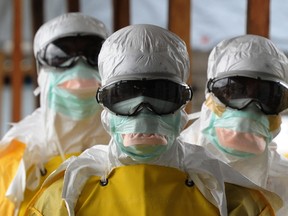 Health care workers, wearing protective suits, leave a high-risk area at the French NGO Medecins Sans Frontieres (Doctors without borders) Elwa hospital on August 30, 2014 in Monrovia.
