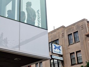 People stand near a second floor window in Fanshawe College's Centre for Digital and Performance Arts, across the street from the former Kingsmill's department store, on Dundas Street in London, Ontario on Tuesday September 2, 2014. (CRAIG GLOVER, The London Free Press)