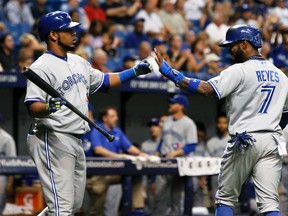 Toronto Blue Jays shortstop Jose Reyes (left) is congratulated by first baseman Edwin Encarnacion after scoring against the Tampa Bay Rays at Tropicana Field in St. Petersburg, Fla., Sept. 2, 2014. (KIM KLEMENT/USA Today)