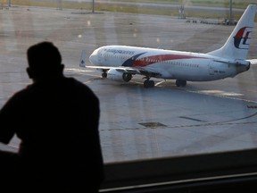 A man watches a Malaysia Airlines jet at Kuala Lumpur International Airport on July 25, 2014. (REUTERS/Olivia Harris)