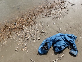 A jacket lays washed up on the edge of North Saskatchewan River as the Edmonton Police Service, RCMP and partnering organizations conducted a sweep of the river in an effort to locate any potential human remains, in Edmonton Alta., on Wednesday Sept. 3, 2014. David Bloom/Edmonton Sun