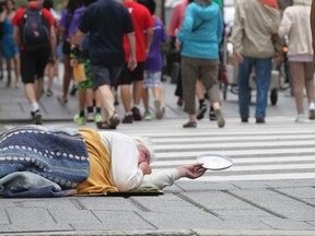 A homeless man attempts to collect some spare change in downtown Toronto. (File photo)