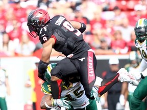 Stampeders RB Jon Cornish is challenged by Eskimos LB Dexter McCoil Monday during the Labour Day Classic in Calgary. (Dexter Makowichuk, QMI Agency)