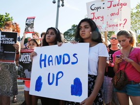 Protesters call for a thorough investigation of the shooting death of teen Michael Brown in Ferguson, Missouri, on a street in front of the White House in Washington, August 28, 2014. (REUTERS/Larry Downing)