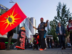 Demonstrator Joe Taylor marches with a Mohawk flag during a protest on the streets following the federal government's approval of the Enbridge's Northern Gateway pipeline in Vancouver, British Columbia.

REUTERS/Ben Nelms
