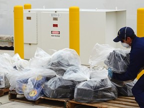Coast Guard personnel offloads part of a 2,800-kilogram cocaine seizure at the Coast guard base in Miami Beach, Florida September 4, 2014. Nearly three dozen United States Coast Guard personnel spent more than an hour unloading almost $93 million of cocaine after it was seized in the Caribbean near Panama in late August.  REUTERS/Zachary Fagenson
