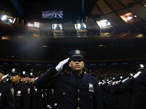 Members of the June 2014 graduating class of the New York City Police Academy salute during their graduation ceremony at Madison Square Garden in New York June 30, 2014. 
REUTERS/Shannon Stapleton