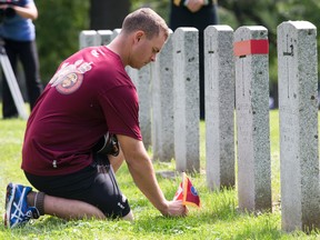 Master corporal Scott Lawrence places a flag at the grave of Arthur H. Bremner, an original member of Princess Patricia?s Canadian Light Infantry, at Woodland Cemetery  in London on Thursday. The PPCLI Memorial Baton Relay team  made a stop to honour the eight members interned at the cemetery. The team is running from Edmonton to Ottawa with a baton containing the names of 1,866 members who have fallen in active service since infantry?s formation in 1914. DEREK RUTTAN/ The London Free Press