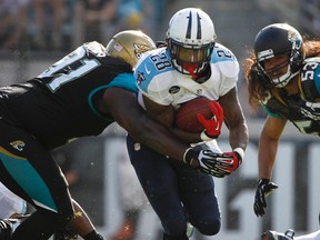 Tennessee Titans running back Chris Johnson (28) runs with the ball as Jacksonville Jaguars defensive end Abry Jones (91) defends during the first half at EverBank Field on Dec 22, 2013 in Jacksonville, FL, USA. (Kim Klement/USA TODAY Sports)