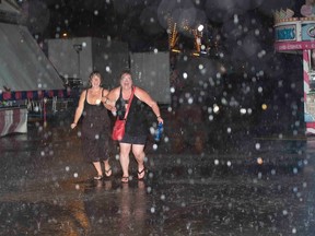 Fans of The Sheepdogs, Pam Harbottle, left, and Jeri-Lea Prince get soaked after the concert at Western Fair was cancelled due to the weather on Friday. The women had a great time despite the no-show as they had backstage passes, met the band and had their copies of Rolling Stone Magazine autographed. (DEREK RUTTAN, The London Free Press)