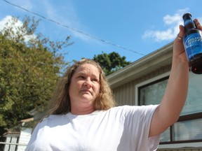 London resident Sharon Daley, 40, holds up the bottle of Bud Light. (DALE CARRUTHERS, The London Free Press)