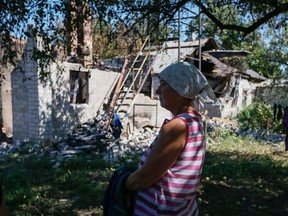 A local woman reacts as she stands near her residence which was damaged during fighting between the Ukrainian army and pro-Russian separatists, in Pervomayskoe near Donetsk September 6, 2014. REUTERS/Gleb Garanich