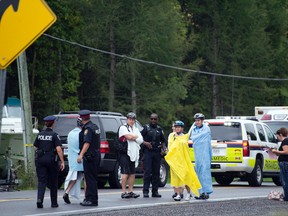 Police and paramedics tend to bystanders after a 40-year-old woman cyclist died after being struck by a dump truck during the Ride the Rideau charity bike ride on Saturday, Sept. 6, 2014. (Dani-Elle Dube/Ottawa Sun)
