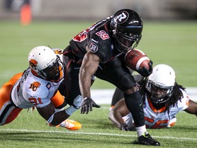 Ottawa RedBlacks Chevon Walker eludes the tackles of B.C. Lions Ryan Phillips (#21) and Soloman Elimimian during first half CFL football action at TD Place in Ottawa.d September 5, 2014. Errol McGihon/Ottawa Sun/QMI Agency