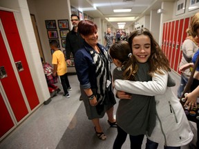 Meridith Gusnowsky (r) hugs her buddy Diana LeBlanc on the first day of school at Victoria School of the Arts in Edmonton, Alberta on September 2, 2014. Perry Mah/Edmonton Sun/QMI Agency