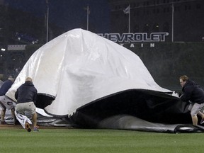 The ground crew at Comerica Park lose control of the tarp while trying to cover the field as a storm hits during the third inning of the Detroit Tigers game against the San Francisco Giants September 5, 2014, in Detroit, Michigan.  (Duane Burleson/Getty Images/AFP)
