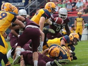 Queen's running back Jonah Pataki fumbles the ball while running through the Ottawa defence during the first quarter of Saturday's game at Richardson Stadium in Kingston on  Sept. 6, 2014. Ottawa would recover the ball and jump out to an early 14-0 lead.ELLIOT FERGUSON/KINGSTON WHIG-STANDARD/QMI AGENCY