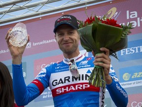 Garmin Sharp's Canadian cyclist Ryder Hesjedal celebrates his victory on the podium of the 14th stage of the 69th edition of "La Vuelta" Tour of Spain, a 200,8 km ride from Santander to La Camperona on September 6, 2014. (AFP PHOTO/ JAIME REINA)