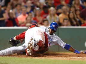 Blue Jays outfielder John Mayberry Jr. slides safely into home in the 10th inning against the Boston Red Sox at Fenway Park on Friday night. (USA Today Sports)