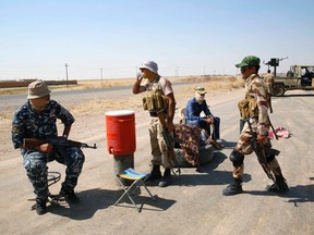 Fighters from the Shi'ite Badr Brigade militia guard a checkpoint along a highway recently taken from militants of the Islamic State outside the town of Sulaiman Pek September 5, 2014. The highway, which continues south to Baghdad, is now controlled by Shi'ite militia fighters and the Kurdish Peshmerga. REUTERS/Ahmed Jadallah