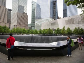 Visitors look out onto a pool in the National September 11 Memorial during the first day of unfettered public access to the site in New Yorkin this May 21, 2014 file photo. REUTERS/Lucas Jackson