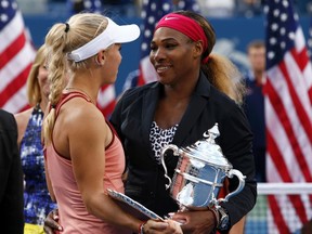 Serena Williams of the U.S. (R) and Caroline Wozniacki of Denmark chat as they hold their trophies after Williams won their women's singles finals match at the 2014 U.S. Open tennis tournament in New York, September 7, 2014.  (REUTERS)