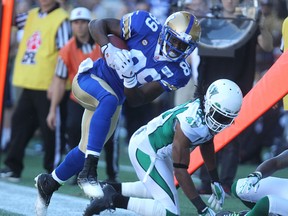 Winnipeg Blue Bombers SB Clarence Denmark tries to keep his balance on the sideline during CFL action against the Saskatchewan Roughriders in the Banjo Bowl at Investors Group Field in Winnipeg, Man., on Sun., Sept. 7,2014. Kevin King/Winnipeg Sun/QMI Agency