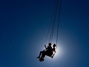 The sun is eclipsed by fair goers riding the Vertigo giant swing ride at Western Fair in London Ontario on Sunday, September 7, 2014. (DEREK RUTTAN, The London Free Press)