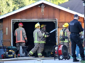 Chatham firefighters put out a few remaining hotspots in a garage that caught fire early Sunday evening, Sept. 7, 2014, on Spurgeon Drive in Chatham, Ont. Mayor Randy Hope and Blackburn Radio news reporter Mike James were the first on the scene to try to keep the fire under control. ELLWOOD SHREVE/ THE CHATHAM DAILY NEWS/ QMI AGENCY