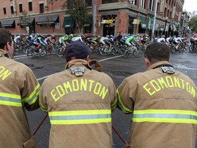 Firefighters from Station 2 watch the final stage of the Tour of Alberta makes its way through Edmonton Alta., on Sunday Sept. 7, 2014. David Bloom/Edmonton Sun/QMI Agency