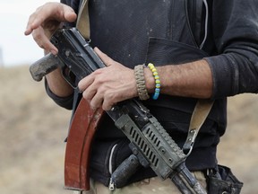 A soldier from the Ukrainian self-defence battalion "Azov" carries his weapon as he stands guard at a checkpoint in the southern coastal town of Mariupol September 8, 2014. REUTERS/Vasily Fedosenko