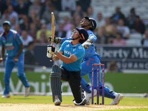 England's Alastair Cook hits the ball in the air before being caught by India's Mahendra Singh Dhoni (right) during the fifth one-day international cricket match at Headingley cricket ground. (Reuters)