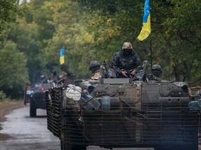 Ukrainian servicemen ride on an armoured vehicle near Kramatorsk September 8, 2014.  REUTERS/Gleb Garanich