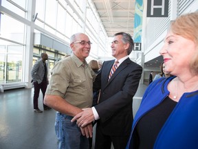 Candidate Jim Prentice (centre) hugs former Edmonton Mayor Stephen Mandel (left), alongside his wife Karen, during the 2014 PC Leadership Vote at the Edmonton Expo Centre in Edmonton, Alta., on Saturday, Sept. 6, 2014. Three candidates, Thomas Lukaszuk, Jim Prentice and Ric McIver are candidates. Ian Kucerak/Edmonton Sun