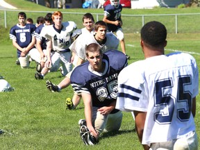 The Notre Dame Alouettes stretch ahead of senior boys football practice Monday.