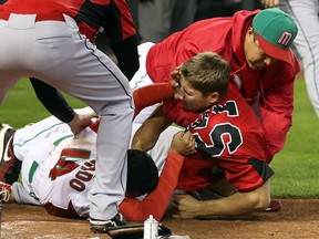 Canada’s Jay Johnson (right) and Eduardo Arredondo of Mexico go at it during the World Baseball Classic last year. (Getty Images)