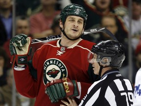 Minnesota Wild left wing Derek Boogaard (L) is separated by linesman Mark Pare as he makes his way to the penalty box during the second period against the Vancouver Canucks in St. Paul, Minnesota in this January 13, 2010 file photo.  (REUTERS)