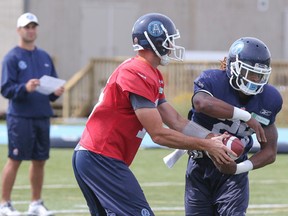 Ricky Ray hands off to Curtis Steele yesterday at the Argos’ new practice facility at Downsview Park. (Dave Thomas/Toronto Sun)