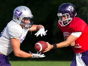 Western Mustangs backup quarterback Stevenson Bone hands the ball off to Adam Sinclair, left, during practice on Tuesday. Getting the ball in Sinclair?s hands more frequently is one of head coach Greg Marshall?s priorities on offence. (CRAIG GLOVER, The London Free Press)