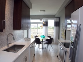The Quartz features a bright galley kitchen with contrasting high-gloss white and dark brown cabinets.