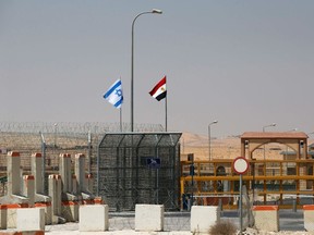 An Israeli flag (L) flutters next to an Egyptian one at the Nitzana crossing, along Israel's border with Egypt's Sinai desert, as seen from the Israeli side August 20, 2013. (REUTERS/Ronen Zvulun)